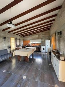 a large room with a table and a kitchen at Chacra El Timbó in Tacuarembó