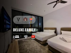 1 Schlafzimmer mit 2 Betten, einem TV und einem Fenster in der Unterkunft Scarletz Suites KLCC by De Harlequins Guesthouse in Kuala Lumpur