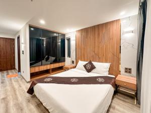 a bedroom with a large bed and a large mirror at DA NANG BAY HOTEL in Da Nang