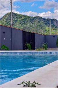 a swimming pool with blue water in front of a mountain at CHcasaquinta in Paraguarí