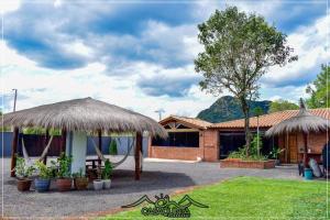 a house with a grass roof and a patio at CHcasaquinta in Paraguarí
