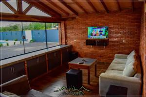 a living room with a tv on a brick wall at CHcasaquinta in Paraguarí