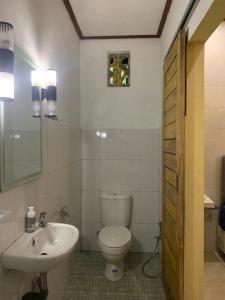 Un baño blanco con inodoro y lavabo. en Villa Kubu Gitgit, en Gitgit