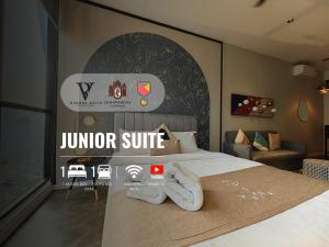 a bedroom with a bed with a jurer suite sign on the wall at Scarletz Suites KLCC by De Harlequins Guesthouse in Kuala Lumpur