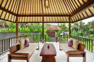 een prieel met twee banken en een tafel op een veranda bij Romance Forest view 2 BR Private Pool Villa ZN21 in Ubud