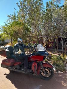 un hombre está sentado en una motocicleta roja en Hospedaje Familiar Raza Mistica en Villa Unión
