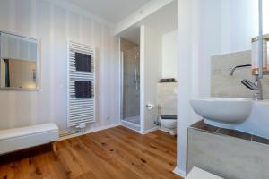 een witte badkamer met een wastafel en een toilet bij Hotel Villa Wahnfried Thiessow in Thiessow +253 foto's