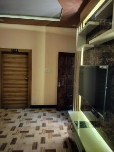 sala de estar con TV y puerta en Shree Nanda Guest House en Varanasi