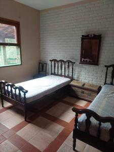 a bedroom with two beds and a window at Casa de estadia, lazer e encontros in Três Corações