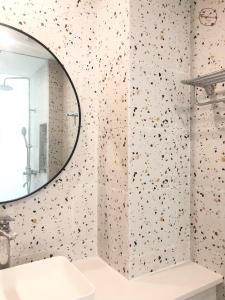 een badkamer met een spiegel en een witte wastafel bij Fun Hotel in Panglao