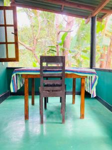 a wooden table with a chair sitting at it at Sigiri Ruvini Homestay in Sigiriya