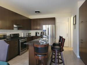 a kitchen with a counter and some chairs in it at Jack & Jill Private Suite @RoseGlen Place in Stamford