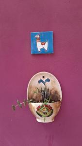 a vase on a wall with a picture on it at Hospedaje Familiar Raza Mistica in Villa Unión