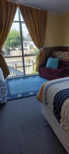 a bedroom with a bed and a large window at Bed and Breakfast Happy Home Taupo Accommodation in Taupo