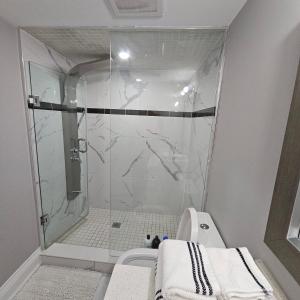 a bathroom with a shower and a toilet in it at Basement Apartment in Luxury Beach House in Toronto
