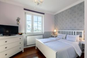 - une chambre avec un lit blanc et une télévision dans l'établissement Hotel Villa Wahnfried Thiessow, à Thiessow