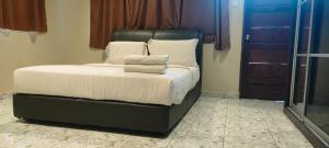 1 cama con sábanas blancas y almohadas en una habitación en DD Homestay, en Kota Kinabalu