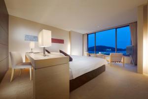 鳥羽的住宿－圖巴國際酒店，酒店客房配有一张床、一张书桌和一台电视。