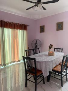 Kampong Sungai LayarにあるTeratak Kasih Homestayのダイニングルーム(椅子、シーリングファン付)