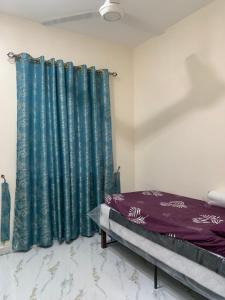 Kampong Sungai LayarにあるTeratak Kasih Homestayの緑のカーテン付きのベッドルーム1室、ベッド1台が備わるベッドルーム1室が備わります。