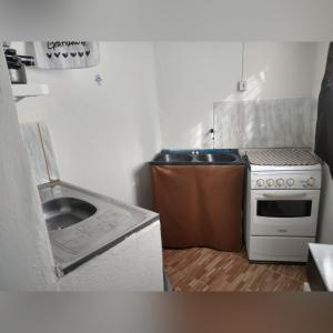 uma pequena cozinha com um fogão e um lavatório em APÊ AVENIDA - BONITO/PE em Bonito