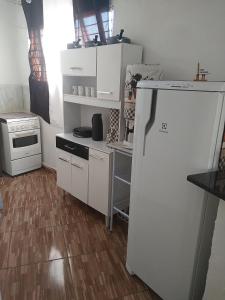 uma cozinha com um frigorífico branco e um fogão em APÊ AVENIDA - BONITO/PE em Bonito