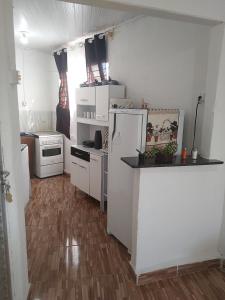 uma cozinha com electrodomésticos brancos e piso em madeira em APÊ AVENIDA - BONITO/PE em Bonito