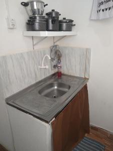 a kitchen counter with a sink and some pots and pans at APÊ AVENIDA - BONITO/PE in Bonito