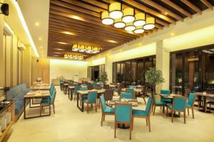 a restaurant with blue chairs and tables in a room at Wave Sea 1 BR Superior Room ZN30 in Senggigi 