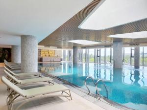 una gran piscina con sillas en un edificio en A La Carte - Modern Residence, en Ha Long