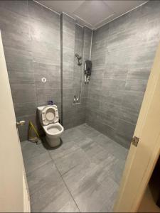 a bathroom with a toilet and a tiled wall at J&SM Riverine resort homestay in Kuching