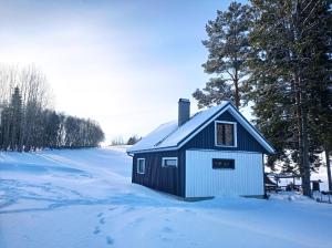 un pequeño edificio blanco y negro en la nieve en Seto Kapten, en Meremäe
