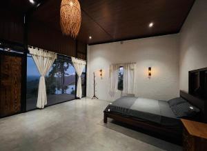 a bedroom with a bed and a large window at Star Hill Dak Nong Retreat in Gia Nghĩa
