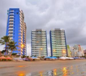 a city with tall buildings and umbrellas on a beach at Tonsupa Diamond Beach in Tonsupa