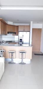 a kitchen with a counter and two bar stools at Tonsupa Diamond Beach in Tonsupa