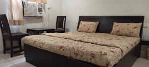 1 cama en un dormitorio con silla y 1 cama sidx sidx sidx sidx en RANGBAARI STAYS & CAFE, en Jodhpur