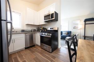 a kitchen with white cabinets and a black stove top oven at Bright Pacifica Townhouse in Pacifica