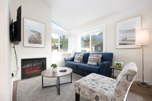 a living room with a blue couch and a fireplace at Bright Pacifica Townhouse in Pacifica