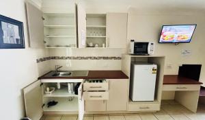 a small kitchen with a sink and a refrigerator at Motel Myall in Dalby