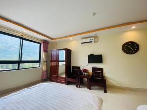 a bedroom with a bed and a clock on the wall at Khách Sạn - Nhà Hàng So Oanh - Gần Thác Bản Giốc in Cao Bằng