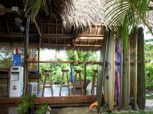 a room with chairs and a bar with surfboards at Single Fin Siargao in General Luna