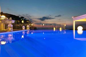 a large swimming pool at night with blue illumination at Hotel Rivage in Sorrento
