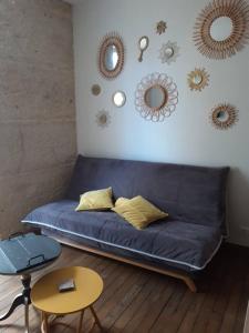 - un canapé bleu dans une chambre avec des miroirs sur le mur dans l'établissement Appartement d'une chambre avec wifi a Dijon, à Dijon