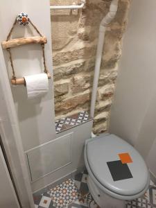 La salle de bains est pourvue de toilettes et d'un mur en pierre. dans l'établissement Appartement d'une chambre avec wifi a Dijon, à Dijon