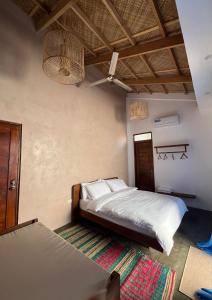 1 dormitorio con 1 cama y ventilador de techo en Single Fin Siargao en General Luna
