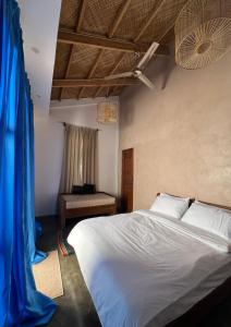 Un dormitorio con una cama grande con una cortina azul en Single Fin Siargao en General Luna