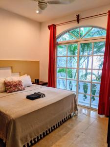 um quarto com uma cama e uma grande janela em Castillo Playacar Fase 1 9br 3Kitchen Pool walk to Beach 5th Ave 25max em Playa del Carmen