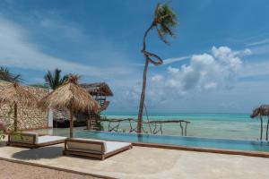 a swimming pool with a view of the ocean at Be Zanzibar Boutique Hotel in Mfumbwi