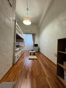 a large room with wooden floors and bunk beds at Guesthouse Iyonchi in Zamami