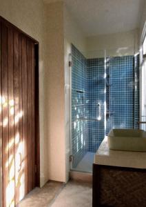 a bathroom with a glass shower with a sink at Single Fin Siargao in General Luna +30 photos